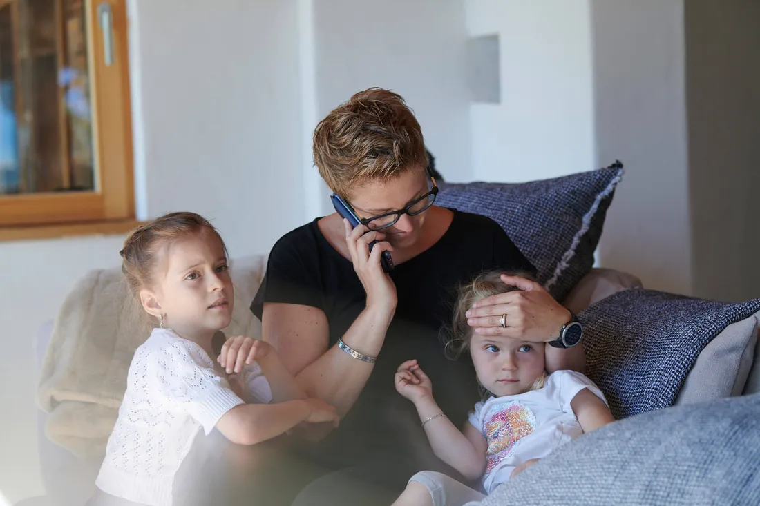 Mutter telefoniert besorgt wegen krankem Kind