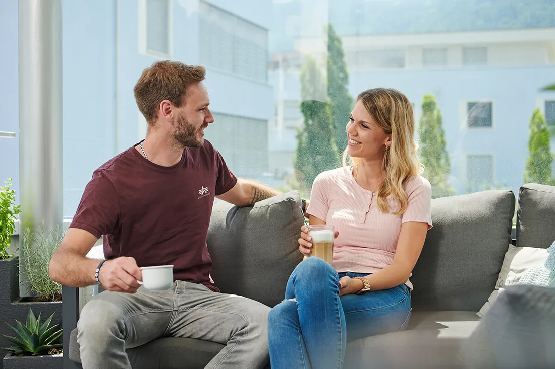 Mann und Frau auf Sofa beim Kaffee