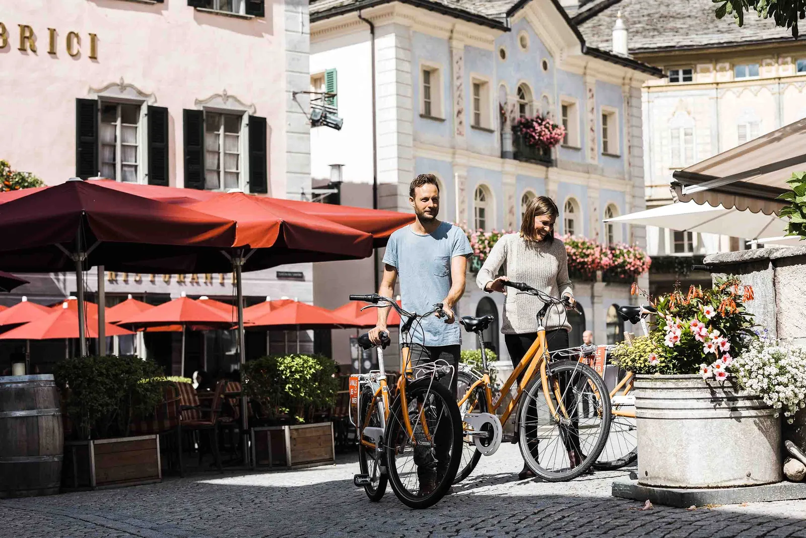 Couple poussant des vélos dans une vieille ville pittoresque