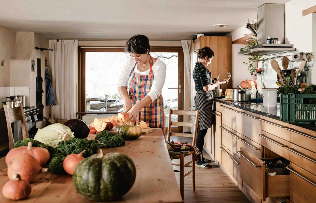 Zwei Personen bereiten gemeinsam in einer Küche frisches Gemüse zu