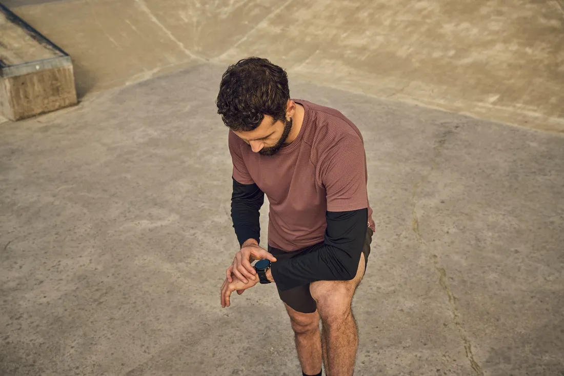 Eine Person prüft während einer Trainingseinheit die Daten auf einer Sportuhr.