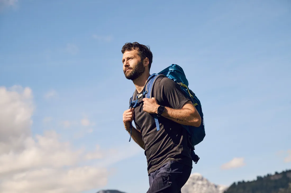 A person with a backpack is hiking through an alpine mountain landscape.