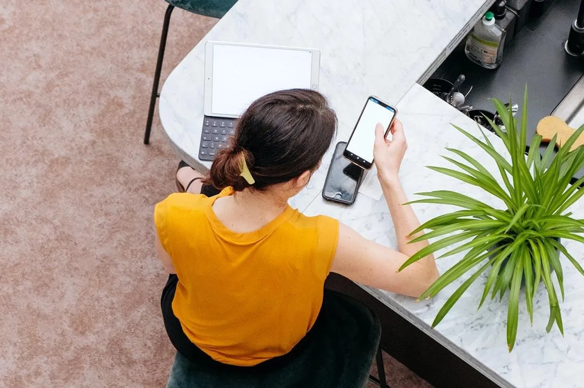 Frau studiert an Laptop und Smartphone