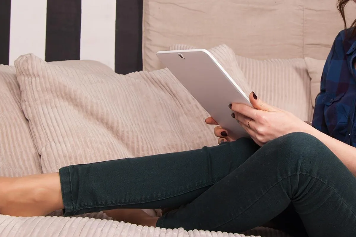 Frau mit Tablet auf dem Sofa