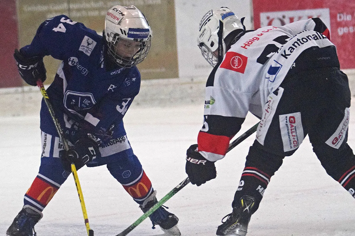 Zwei junge Eishockeyspieler beim Zweikampf