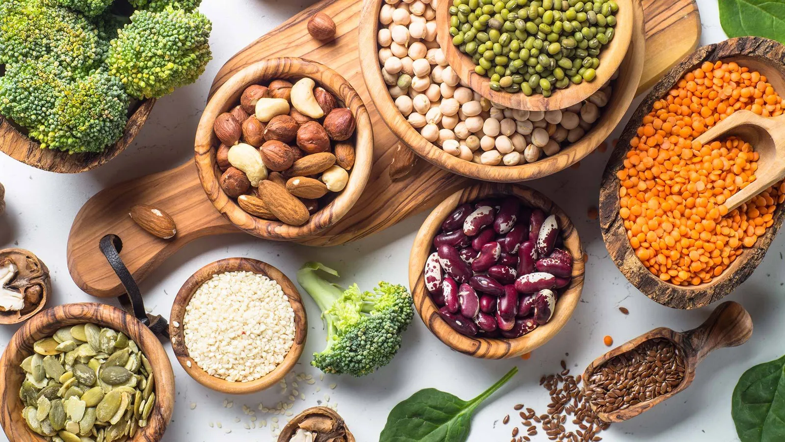 Reich belegter Tisch mit Broccoli, Nüssen, Hülsenfrüchten und mehr