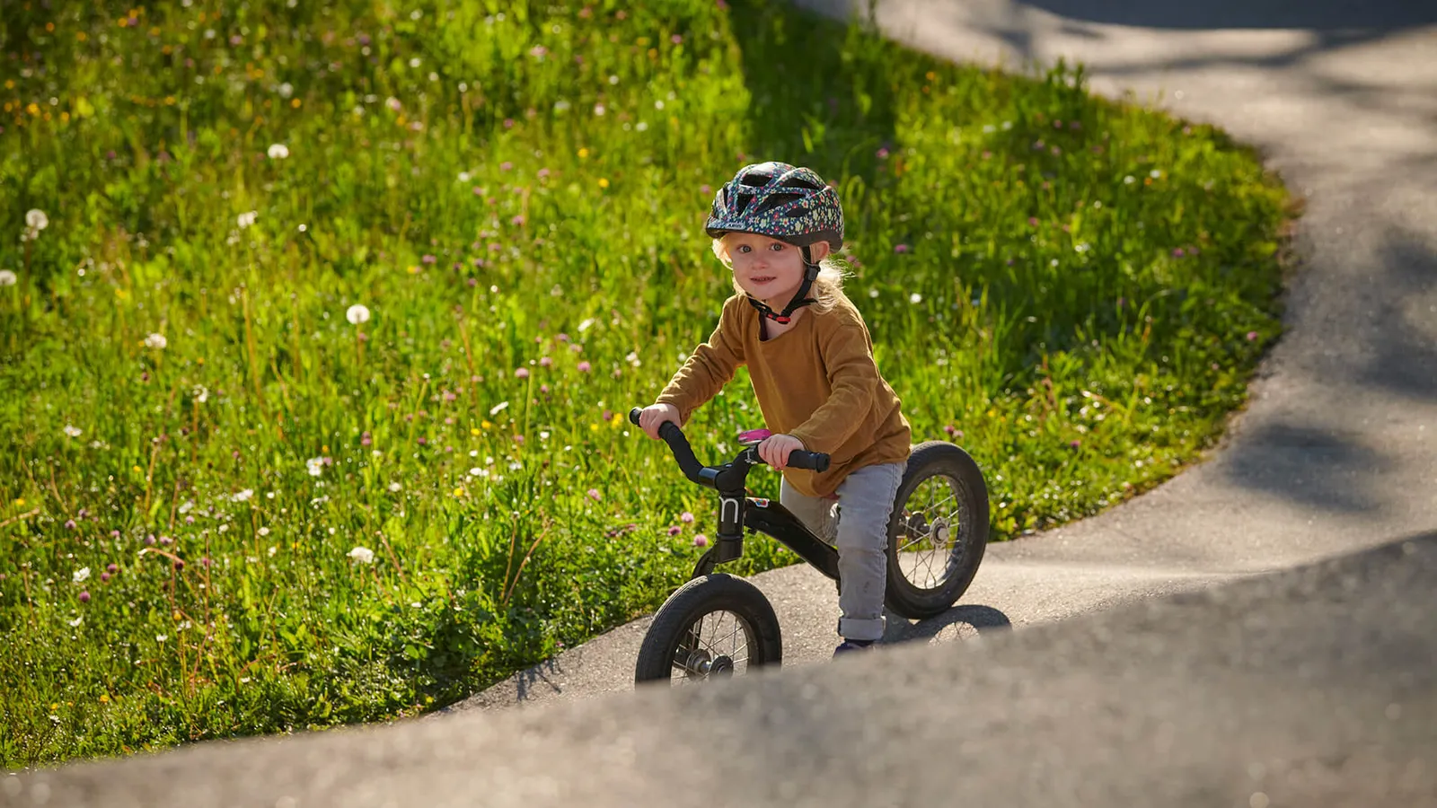 Mädchen mit Laufrad auf Pumptrack