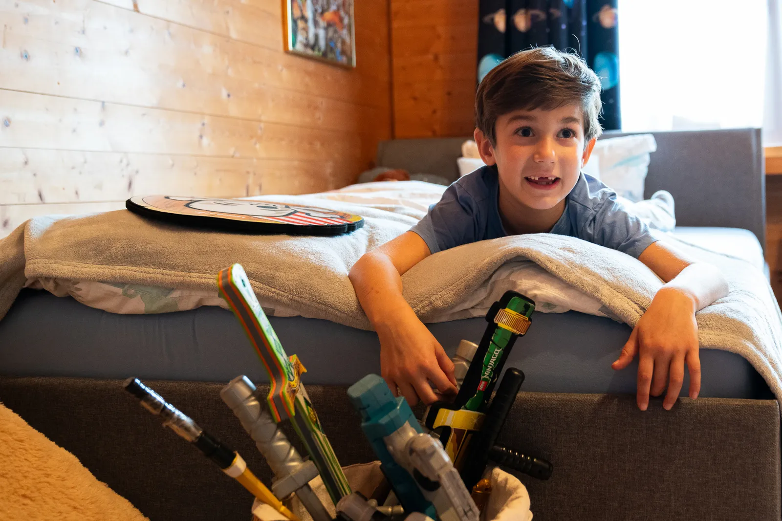 Junge liegt auf dem Bett in seinem Kinderzimmer