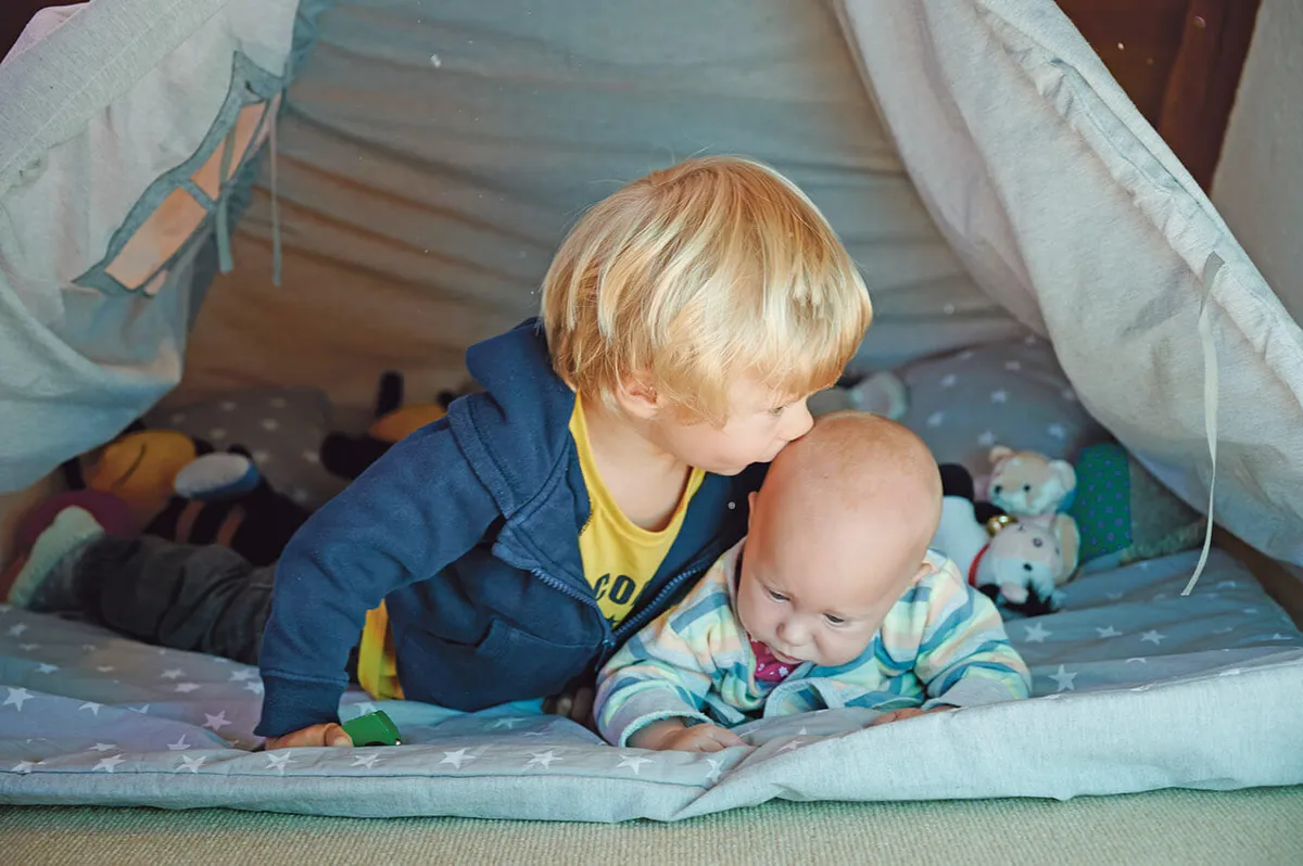 Zwei kleine Kinder in einem Tipi-Zelt im Kinderzimmer