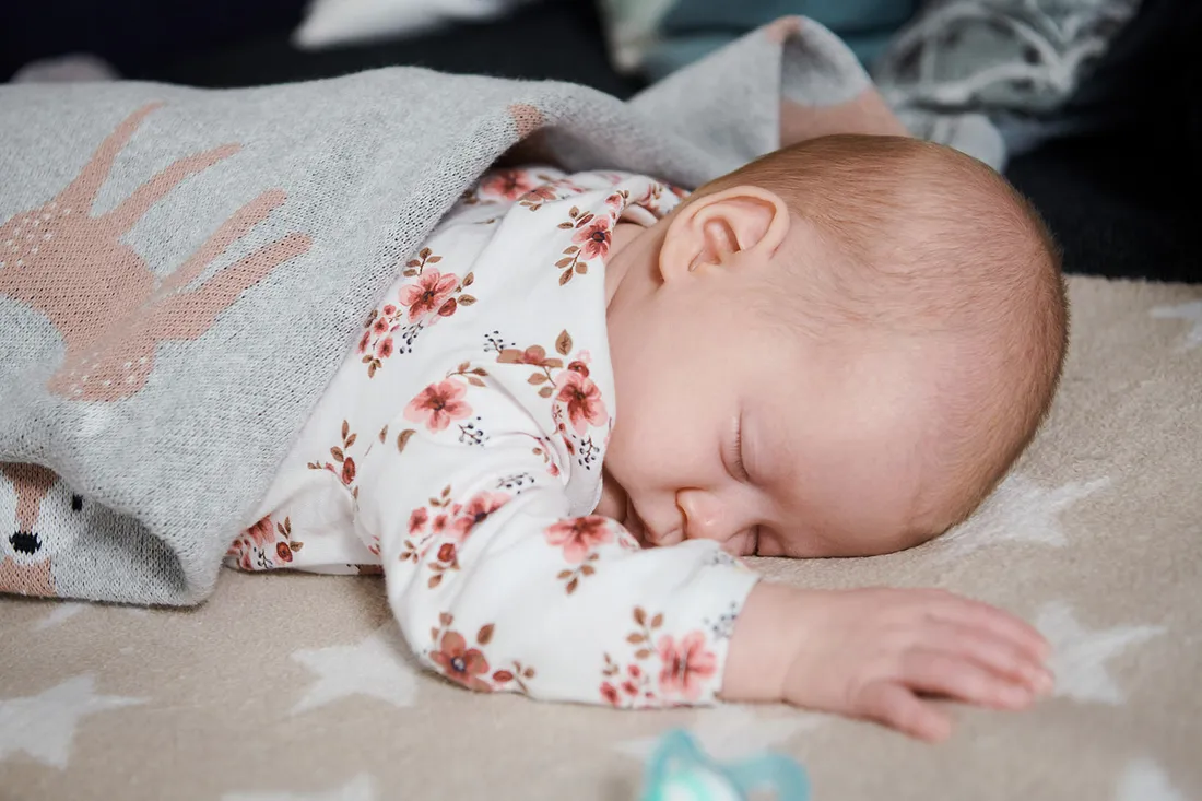 Baby liegt auf einer Decke