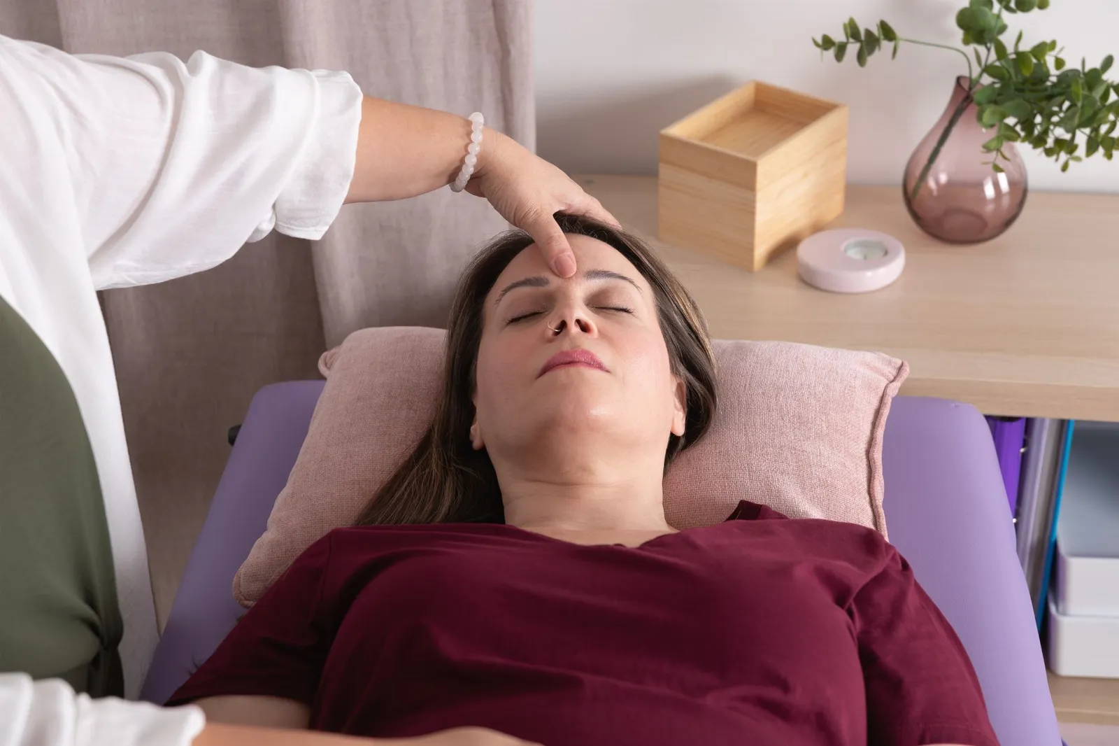 Frau liegt in Therapie in der Kinesiologie