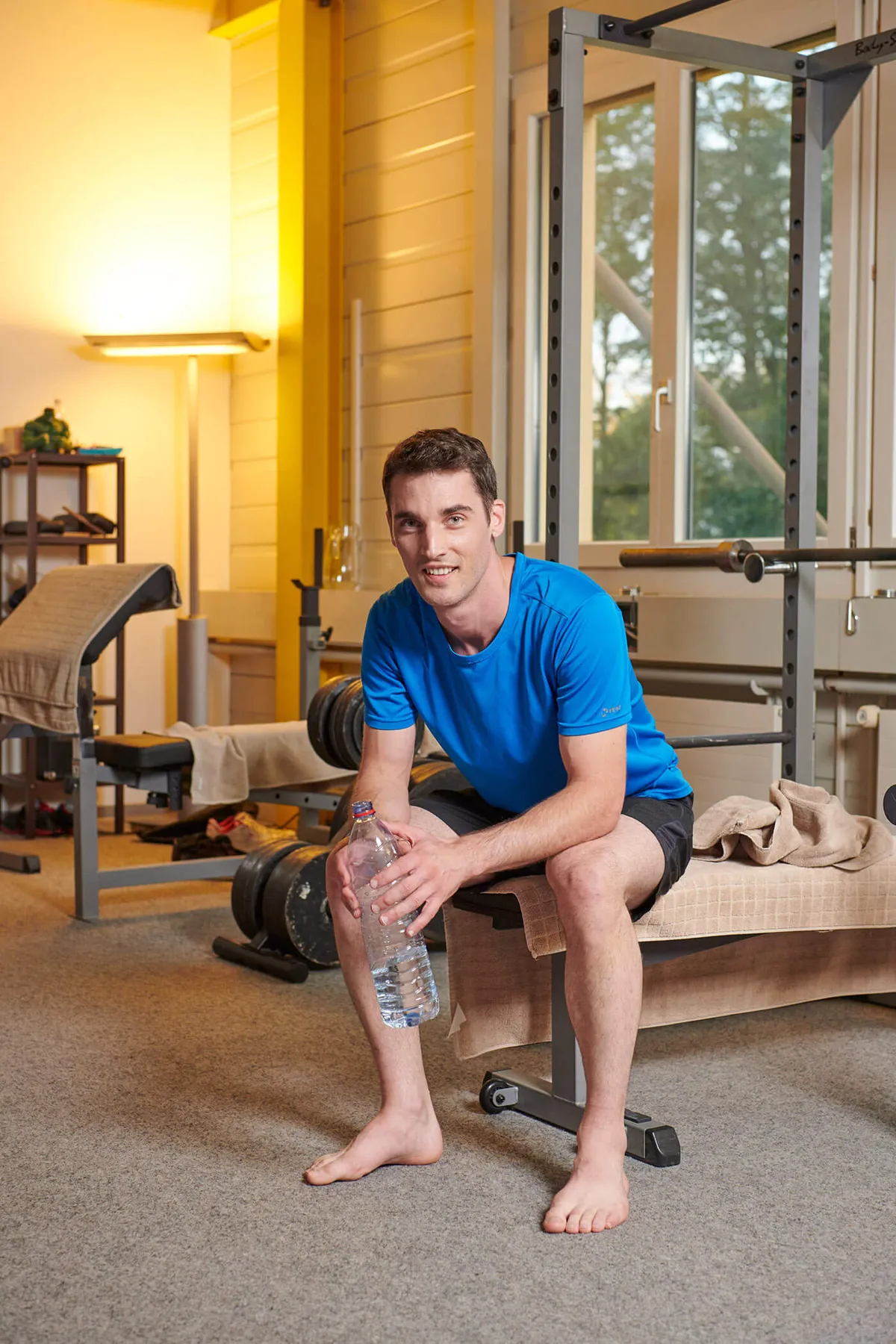 Mann sitzt im Fitnesestudio