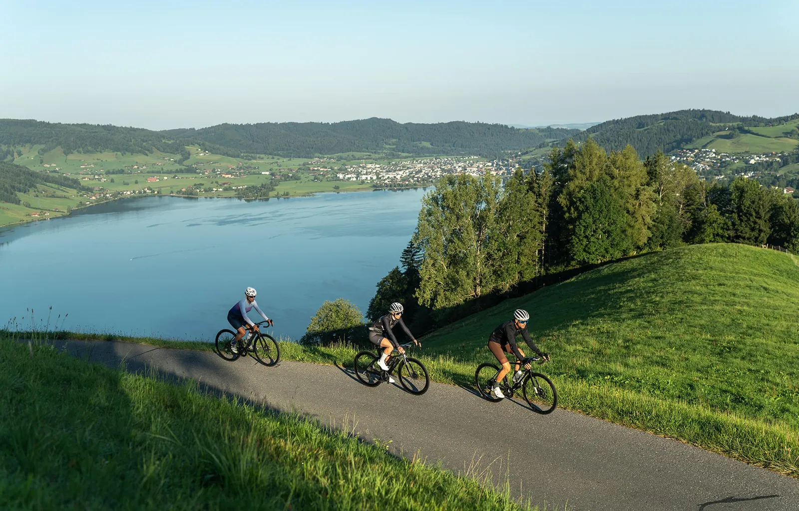 Drei Rennvelofahrer über einem See