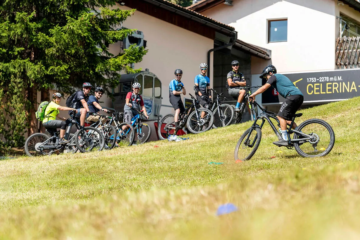 Mann zeigt einer Gruppe Fahrtechnik beim Biken