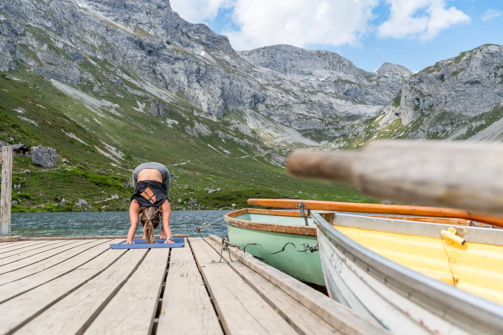 Frau macht Yoga an einem Bergsee