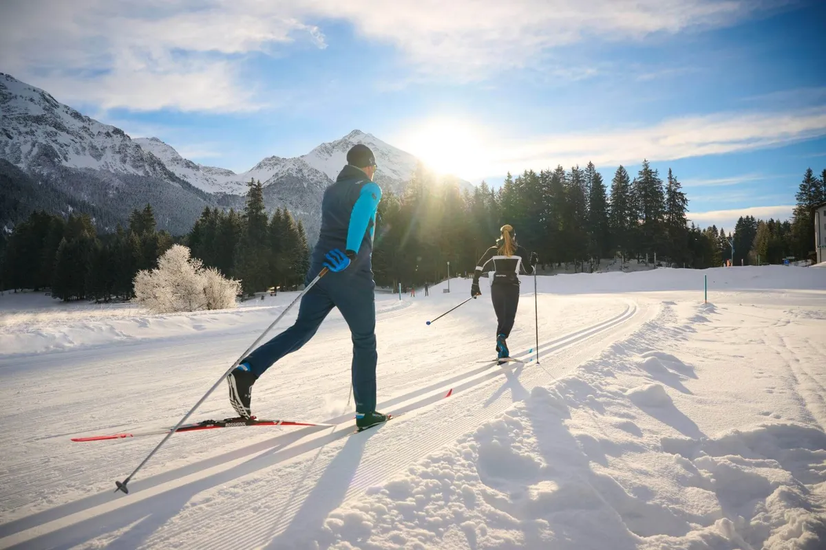 Zwei Personen laufen in der klassischen Langlaufloipe