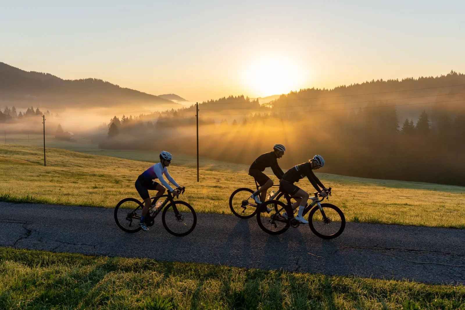3 Radfahrer bei schöner Sonnenaufgangsstimmung