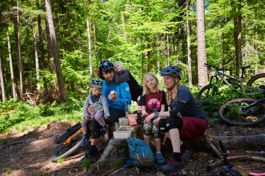Familie macht beim Bike eine Pause im Wald