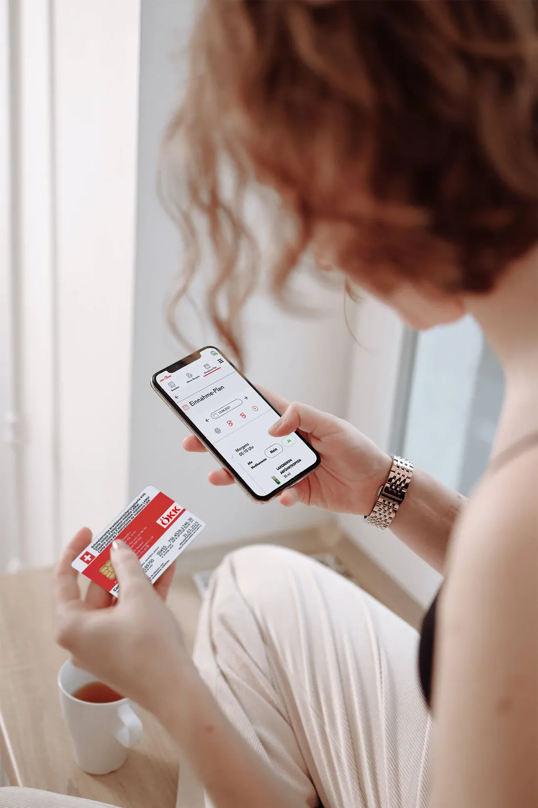 Donna che tiene una tessera sanitaria e uno smartphone con un'app sanitaria