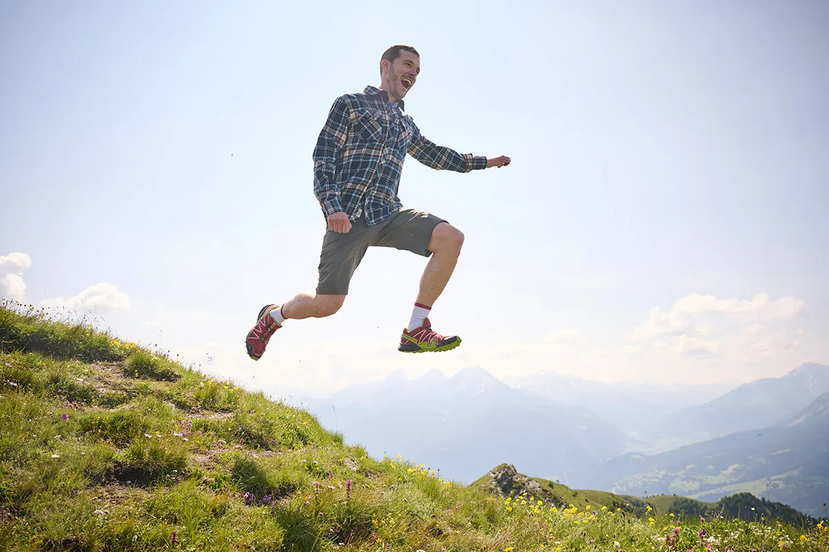 Mann macht Luftsprung auf einer Wiese