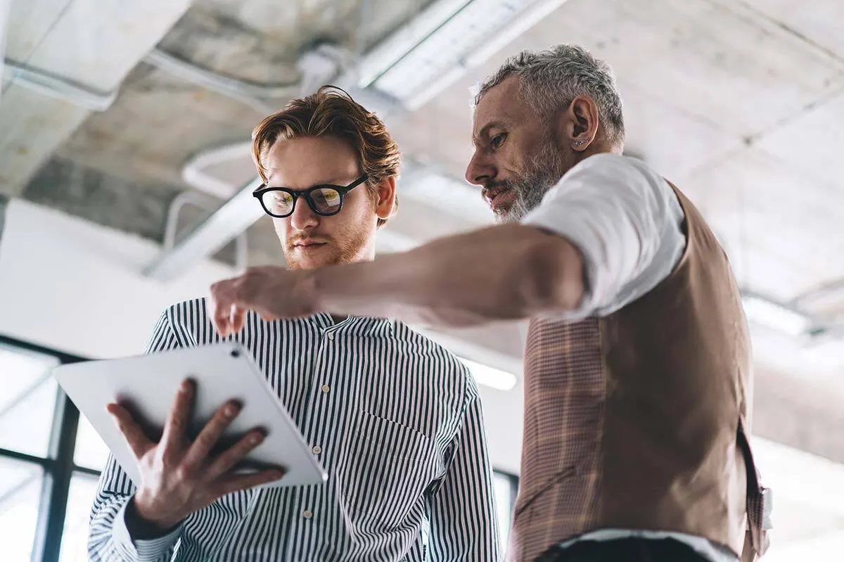 Zwei Männer diskutieren eine Thematik am Tablet