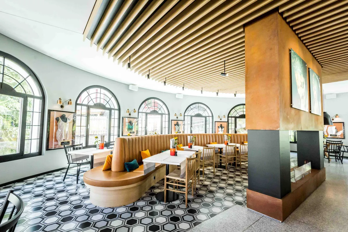 Modern eingerichtetes Restaurant mit geschwungener Sitzbank, grossen Rundbogenfenstern und stilvollem Interior im Hard Rock Hotel Davos.