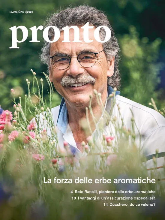 Copertina della rivista ÖKK clever edizione 3/2025. Un uomo anziano con occhiali, capelli grigi ricci e baffi sorride in mezzo a un prato fiorito. Titoli: “La forza delle erbe”, “Reto Raselli, il pioniere delle erbe”, “Perché conviene un’assicurazione ospedaliera” e “Zucchero – il dolce veleno?”.
