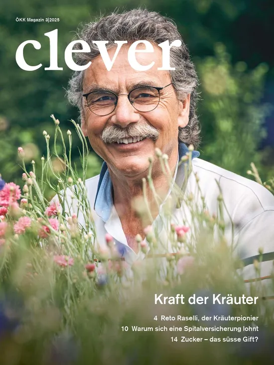 Titelbild des ÖKK Magazins clever 3/2025. Ein älterer Mann mit Brille und grauem Schnurrbart lächelt in die Kamera, umgeben von bunten Blumen und Kräutern. Text auf dem Cover: „Kraft der Kräuter – Reto Raselli, der Kräuterpionier. Warum sich eine Spitalversicherung lohnt. Zucker – das süsse Gift?“.